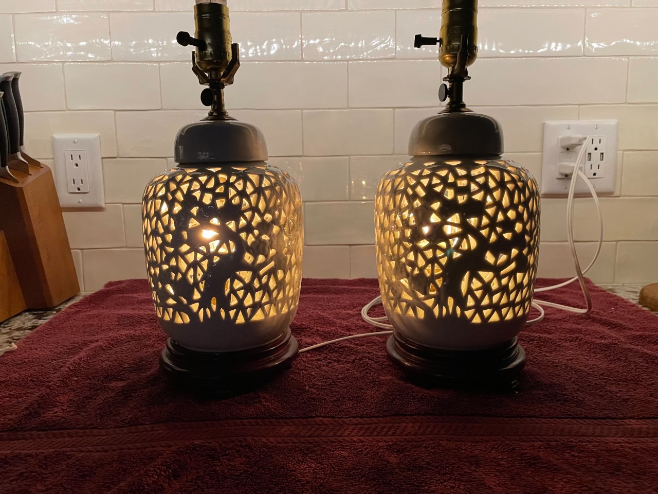 two lamps on the table with lights on